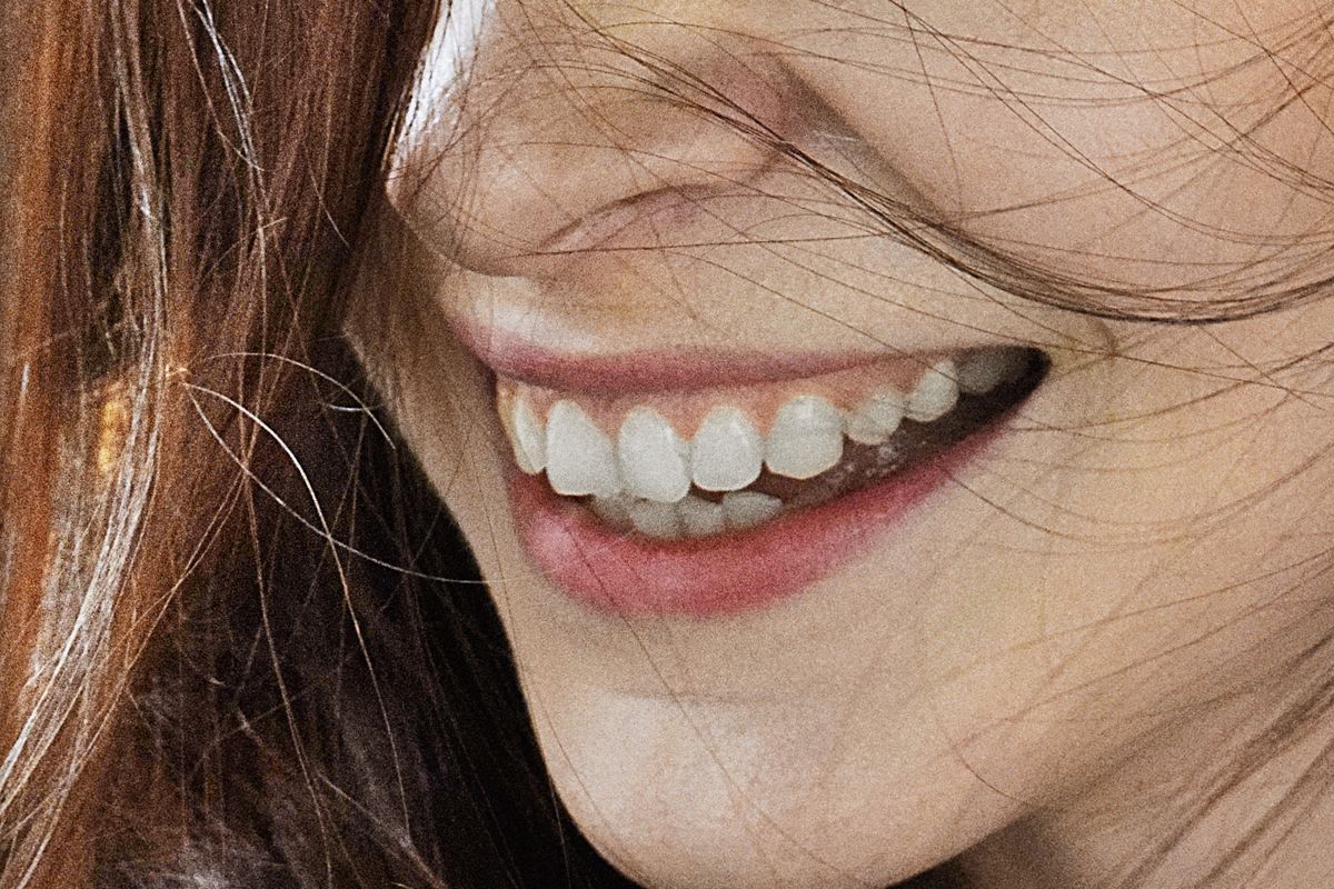 Person with sensitive teeth smiling carefully